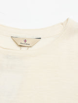 A close-up of the neckline of the BGmonty Knit - Chalk by Blue de Gênes, highlighting the collar stitching and a tag displaying the brand name with a small shield logo above it.