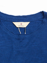 Close-up of the neckline and label of the BGmonty Knit - Navy Peony, a blue knit shirt made from a comfortable cotton-linen blend. The label displays "Blue de Gênes" along with a small shield logo above the text.