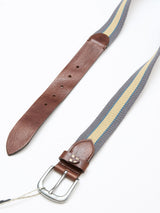 The Blue de Gênes BGcollege Belt - Green Stripe features a webbed strap with green stripes, brown leather ends, and a silver buckle, displayed on a white background.