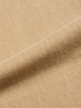 Close-up of a beige fabric with a diagonal seam, showcasing its soft texture and fine weave pattern—distinct from the sturdy feel of rigid denim found in Blue de Gênes BGgiacomo Color Jeans - Tanin.