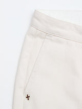 Close-up of the upper section of Blue de Gênes BGpalco Twill Pants in Chalk, crafted from durable cream-colored cotton twill, featuring a waistband, belt loop, side pocket, and a small metal X embellishment near the pocket.