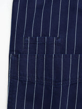 The BGkendrick Toll Jacket - Navy Stripe by Blue de Gênes is crafted from navy blue cotton fabric with fine white vertical stripes, highlighted here with a close-up of the expertly stitched pocket—a classic feature inspired by traditional striped worker jackets.