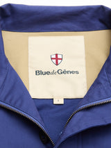 A close-up of the BGcanopy Jacket - Navy Peony from Blue de Gênes, featuring a heavy blue cotton fabric and a beige label with the brand’s name and logo on the inside collar, along with a visible size L tag.