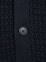 Close-up of the BGbilly S/S Cardigan in Dark Navy by Blue de Gênes, crafted from 100% cotton, featuring a black plastic button sewn onto a ribbed band running vertically down the center.