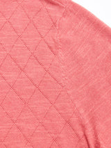 Close-up of the BGwally Diamond Polo in Coral by Blue de Gênes, highlighting a pink fabric with a diamond-knit pattern on the left side and a smoother texture on the right, with a visible seam joining the two sections.