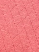 Close-up of the BGwally Diamond Polo in Coral by Blue de Gênes, showcasing the soft, slightly fuzzy texture of its luxurious cotton-linen blend fabric with a diagonal diamond-knit pattern formed by intersecting stitched lines.