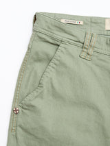 Close-up of Blue de Gênes BGpaulo Pavia Pant in Shadow Green showing a front pocket, belt loop, and shield emblem. Inside waistband label reads Made in Italy with Italian flag. Inspired by vintage military chinos.