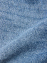 Close-up of BGvinci Hera Used Jeans - Used by Blue de Gênes in mid blue wash, featuring visible weave texture and subtle diagonal crease that highlights the comfort stretch denim in these regular fit jeans.