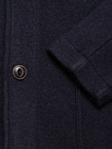 Close-up of the Blue de Gênes Kojima Wool Jacket - Navy, showcasing its textured wool fabric, a brown and black button, and detailed sleeve stitching.