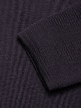 Close-up of the dark, waffle-textured fabric of the Toyama Knit L/S in Dark Navy by Blue de Gênes, with a folded edge highlighting the distinctive pattern and substantial thickness—perfectly showcasing the rich detail of this Merino wool sweater.