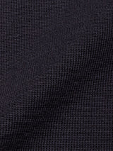 Close-up of a dark, textured fabric with a waffle weave pattern, showing small raised squares and subtle folds in the material—perfectly capturing the refined detail of the Toyama Knit L/S - Dark Navy sweater by Blue de Gênes.