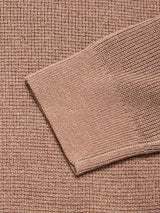 A close-up of the textured, light brown Porto Polo Knit - Fungi by Blue de Gênes, a luxurious men’s long-sleeve polo laid diagonally against a matching fabric background.