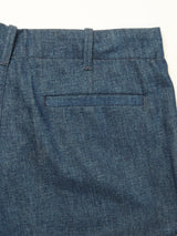 Close-up of the back of blue jeans, featuring a waistband with belt loops and a single welt pocket. The fabric is medium-wash denim with visible stitching, crafted in a style reminiscent of relaxed fit chino designs such as the Blue de Gênes Shogun Fano Pant - Denim Blue.