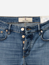 A close-up of BGvinci Girisha Used Jeans by Blue de Gênes in blue comfort stretch denim, with a partially open button fly showing four metallic buttons, front pockets, contrast stitching, and an inner Blue de Gênes label.