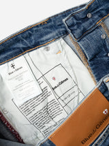 Close-up view inside BGvinci Girisha Used Jeans by Blue de Gênes, showing white inner tags with brand info, washing instructions, and a leather patch reading Blue de Gênes.