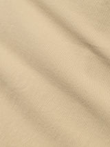 A close-up of Blue de Gênes' BGmenzo Vecchio Chino in Pale Khaki, showing its subtle diagonal ribbed texture and gentle shadows, reminiscent of classic vintage chinos.