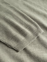 Close-up of the BGmonty Knit - Shadow Green by Blue de Gênes, highlighting the finely stitched sleeve cuff. The cotton linen blend’s texture stands out on a matching surface.