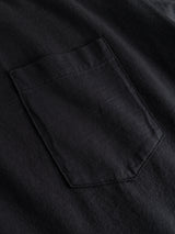 Close-up of a black slub cotton fabric with a sewn-on pocket, showcasing the texture and stitching detail of the BGoscar T-Shirt - Jet Black by Blue de Gênes.