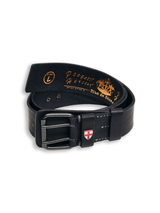 The Cintura Belt - Black by Blue de Gênes is made from cow leather with a metal buckle, white stitching, and a red and white shield emblem on the loop. Gold text and logos decorate the inner side for a stylish touch.