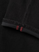 Close-up of the hem on Blue de Gênes BGvinci TrueBlack Jeans in black denim, featuring two parallel red stitches near the edge—highlighting the detailed stitching and textured quality characteristic of comfort stretch denim.