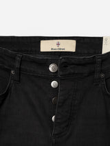 Close-up of the waistband and button fly of the BGrepi TrueBlack Jeans in black denim by Blue de Gênes, featuring visible stitching, branded metallic buttons, and a Blue de Gênes label above the inner waistband—highlighting premium craftsmanship.