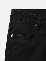 Close-up of the front pocket area of Blue de Gênes BGrepi TrueBlack Jeans in black denim, made from comfort stretch fabric and featuring a small white and red shield-shaped logo on the coin pocket.