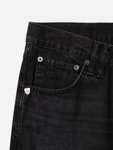 Close-up of the waist and pocket area of the BGmarco Connor Jeans - Black Denim Used by Blue de Gênes, crafted from 100% cotton denim. The relaxed fit is accentuated by metal rivets and a small silver shield-shaped detail on the coin pocket.