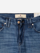 Close-up of blue cotton denim BGmarco Sioux Jeans - Used by Blue de Gênes, showcasing a partially open zipper, visible waistband, belt loops, copper rivets, the signature Blue de Gênes brand label, and a partially visible white care tag on the right side. This pair offers the relaxed fit of Marco Used Jeans for everyday comfort.