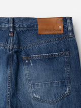 Close-up of the back pocket of Blue de Gênes BGmarco Sioux Jeans - Used, crafted from blue cotton denim with a relaxed fit. A brown leather Blue de Gênes patch is sewn onto the waistband, while the slightly faded finish and visible stitching highlight the signature style.
