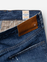 Close-up of the Blue de Gênes BGmarco Sioux Jeans - Used, featuring a brown leather patch with the Blue de Gênes name and small cross logo, as well as an inner label reading “Candiani Denim, Made in Italy.” These relaxed fit jeans showcase visible denim texture and stitching details, crafted from premium cotton for both comfort and style.