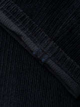 Close-up of navy corduroy fabric from the BGpalco Cord Chino by Blue de Gênes, highlighting its vertical ridges and detailed stitching along a folded edge.