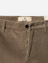 Close-up of Blue de Gênes BGpalco Cord Chino trousers in Sepia Tint Brown, featuring a relaxed fit, visible zipper fly, black button closure, tapered leg, belt loops, and a fabric label with the Blue de Gênes branding on the waistband.