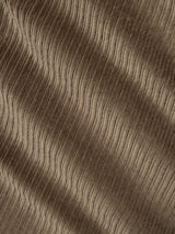Close-up of sepia tint brown corduroy fabric reveals parallel ridges and a soft texture, with light and shadow accentuating the wavy pattern—distinctive features of the BGpalco Cord Chino by Blue de Gênes.