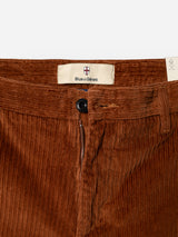 Close-up of Blue de Gênes BGpalco Cord Chino in Ginger Bread Orange, featuring a black button, zipper fly, and an inner Blue de Gênes label on the waistband. These relaxed fit corduroy trousers offer a subtle tapered silhouette for effortless style.