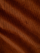 Close-up of ginger bread orange corduroy fabric from the BGpalco Cord Chino by Blue de Gênes, highlighting vertical ridges and a soft, velvety texture with gentle waves—distinctive features of these relaxed fit trousers.