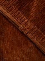 Close-up of ginger bread orange corduroy fabric highlighting its textured, ridged surface and seam details, characteristic of the BGpalco Cord Chino by Blue de Gênes.