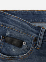 Close-up of the front pocket area of BGvinci OM Jeans - Denim wash by Blue de Gênes, featuring blue denim in a regular fit with visible stitching and a small black leather patch above the coin pocket, highlighting classic five-pocket styling and an authentic worn-in wash.