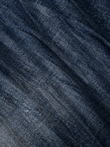 Close-up of dark blue denim fabric from Blue de Gênes’ BGvinci OM Jeans - Denim wash, showcasing a visible woven texture, diagonal creases, and natural light fading for an authentically worn-in look.