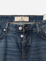 Close-up of the BGrepi Presley Jeans in Denim Blue by Blue de Gênes, featuring brown stitching, a visible Blue de Gênes label, and two metallic buttons engraved with the brand’s shield logo. Crafted from comfort stretch denim, these slim-fit jeans display a slightly worn and faded look.