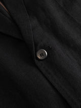 Close-up of the BGleopardi Ian Blazer in black by Blue de Gênes, featuring a single black four-hole button sewn onto soft, slightly textured fabric.