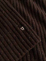 Close-up of the BGcallum Zip Knit in Hot Fudge Brown by Blue de Gênes, displaying its chunky rib-knit fabric with a small, round metallic pin featuring a white cross in the center.