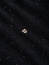 A small metallic shield pin with a cross design is displayed on the richly textured BGadamo Crewneck Knit in Dark Navy by Blue de Gênes, its dark, speckled ribbed fabric and subtle multicoloured nep providing a striking background.