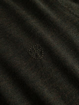 Close-up of the BGhamish Crewneck Knit in Beech Green by Blue de Gênes, made from dark merino wool and featuring a subtle embroidered heart shape outlined with small dots at the center.