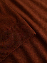 Close-up of the BGhamish Crewneck Knit in Ginger Bread Orange by Blue de Gênes, featuring lightweight knit merino wool fabric with a ribbed cuff folded over a smooth section to emphasize the texture and weave.