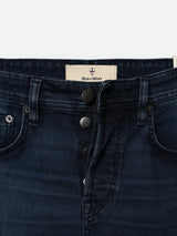 Close-up of blue-black denim BGgiacomo BB Jeans featuring exposed buttons and front pockets. The inner waistband displays the Blue de Gênes label with its distinctive shield logo. Made from rigid denim, these jeans offer a relaxed loose fit for effortless style and comfort.