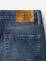 Close-up of the BGvinci Break Jeans - Denim Wash by Blue de Gênes, crafted from comfort stretch denim and featuring a brown leather patch with the brand’s embossed shield emblem above the back pocket.