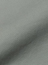 Close-up of the BGpaulo Teo Pant in Shadow Green by Blue de Gênes, showing a light textured fabric with a tight, small-scale pattern and gentle folds that create soft shadows and subtle color variations across the surface.