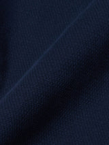 Close-up of the textured dark navy fabric from the Blue de Gênes BGpontus Teo Overshirt, featuring a relaxed fit. A gentle, diagonal fold runs through the center, casting shadows and accentuating the finely woven material.
