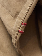Close-up of the beige cotton stretch fabric edge on the Blue de Gênes BGpaulo Pavia 1 V2 Chino - Fungi, showing a seam with red stitches and highlighting the texture and vintage military-inspired details.