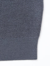 Close-up of the Porto Polo Knit - Dark Slate by Blue de Gênes, highlighting the ribbed hem’s refined texture—a subtle detail that reflects classic polo knit styling against a white background.